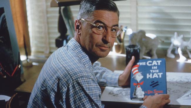 American author and illustrator Dr Seuss (Theodor Seuss Geisel, 1904 - 1991) sits at his drafting table in his home office with a copy of his book, 'The Cat in the Hat', La Jolla, California, April 25, 1957.  (Photo by Gene Lester/Getty Images)