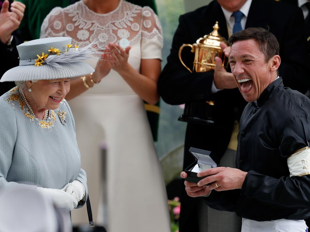 The Queen shares a smile with champion jockey Frankie Dettori after he won the Gold Cup on horse Stradivarius, his fourth win of the day. Picture: AFP