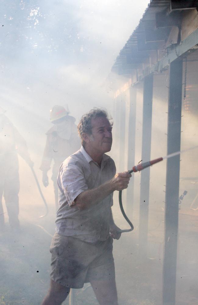 Resident Les Trathen hosing down his home. Picture: David Clark