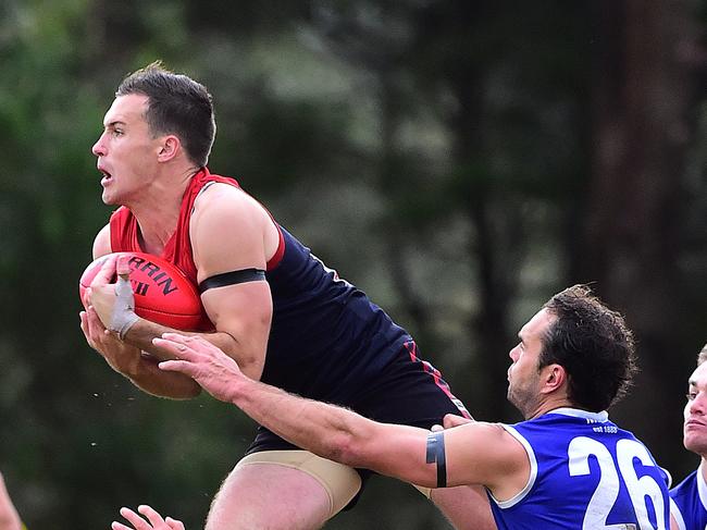 Pictured is action during the Mornington Peninsula Netball Football League ANZAC Day match of Australian Rules football, Mt Eliza in navy blue and red with blue shorts versus Mornington in royal blue, red, white with white shorts at Emil Madsen Reserve on 25 April 2015. Jack Egan takes a screamer. Picture: Derrick den Hollander