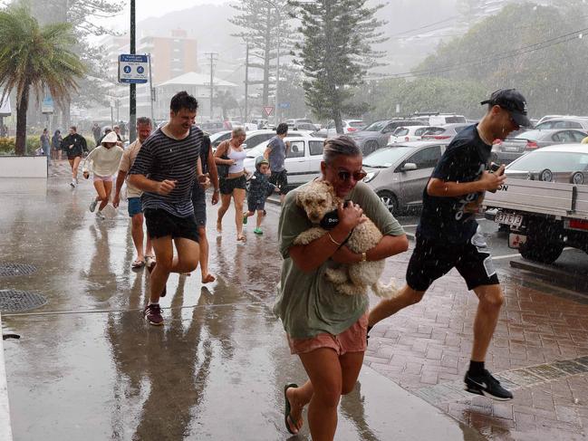 GOLD COAST, AUSTRALIA - NewsWire Photos MARCH 6, 2025: Members of the public run for shelter during a torrential downpour in Burleigh on the Gold Coast ahead of the expected arrival of Cyclone Alfred. Picture: NewsWire/Tertius Pickard