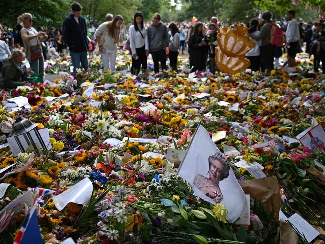 Members of the public look at flowers and tributes to Queen Elizabeth II left in Green Park in London. Picture: Carl De Souza / AFP