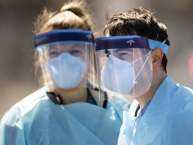 Medical workers in protective masks wait to administer COVID-19 tests at a facility in Camden, N.J., Wednesday, April 1, 2020. The new coronavirus causes mild or moderate symptoms for most people, but for some, especially older adults and people with existing health problems,  it can cause more severe illness or death.(AP Photo/Matt Rourke)