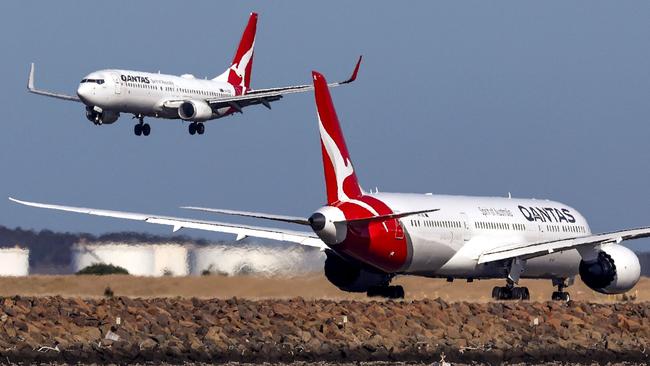 This photo taken on September 4, 2024 shows a Qantas Airways Boeing 737-800 plane coming in to land next to a Qantas Airways Boeing 787 Dreamliner aircraft preparing to take-off at Sydney International Airport. (Photo by DAVID GRAY / AFP)