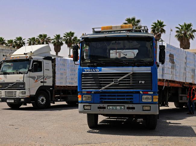 Trucks loaded with humanitarian aid, pass into Rafah in the southern Gaza Strip, through the Kerem Shalom crossing, the main passage point for goods entering Gaza from Israel, on May 21, 2021, after a ceasefire brokered by Egypt between Israel and the Palestinian Hamas movement. - A ceasefire between Israel and Hamas, the Islamist movement which controls the Gaza Strip, appeared to hold today after 11 days of deadly fighting that pounded the Palestinian enclave and forced countless Israelis to seek shelter from rockets. (Photo by SAID KHATIB / AFP)