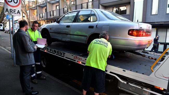 The towing of the cars came as one of the four men was released without charge. Picture: AAP Image/Joel Carrett