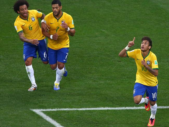 SAO PAULO, BRAZIL - JUNE 12: Neymar of Brazil (R) celebrates after scoring a goal in the first half with Marcelo (L) and Hulk (C) during the 2014 FIFA World Cup Brazil Group A match between Brazil and Croatia at Arena de Sao Paulo on June 12, 2014 in Sao Paulo, Brazil. (Photo by Elsa/Getty Images)