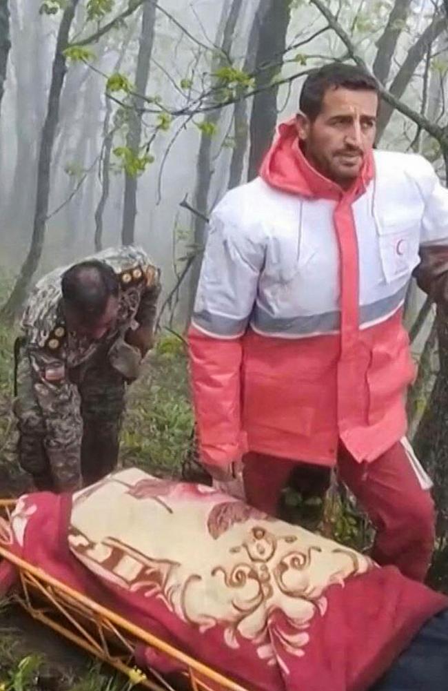 Rescuers recover bodies at the site of President Ebrahim Raisi's helicopter crash in a fog-shrouded mountainous area of northwest Iran. Picture: Iranian Red Crescent / AFP