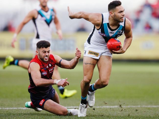 Jarman Impey of the Power runs with the ball away from Christian Salem of the Demons.