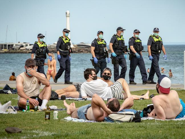 Beachgoers wear masks as social restrictions loosen. Picture: Getty Images