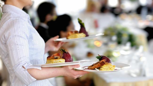 Waitress carrying three plates with meat dish Generic photo of woman working in hospitality industry