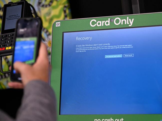 A man takes a picture of the blue screen at self-checkout terminals of a supermarket in Sydney on July 19, 2024. Picture: Saeed KHAN/AFP