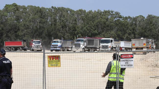 Black Swan Lake protest at Bundall goes to another level, with protesters chaining themselves to the fence and then getting themselves arrested after running onto the worksite and stopping the trucks. The trucks roll in as protesters are taken away in Paddy wagon. Picture Glenn Hampson