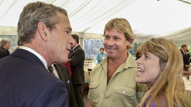 Under strict embargo until Jan 1, 2024 - as provided by the National Archives of Australia. US President George W Bush chats to Terri Irwin and the late Steve Irwin, while Treasurer Peter Costello looks on, during a function in Canberra, October 2003.