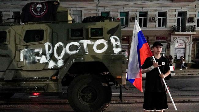 A man holds the Russian national flag in front of a Wagner group military vehicle with the sign read as "Rostov" in Rostov-on-Don. Picture: AFP