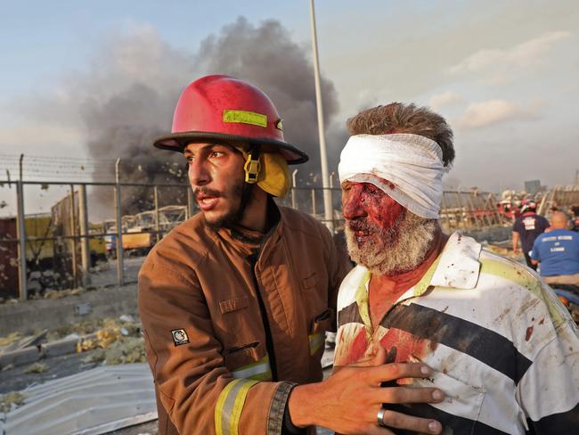 A wounded man is helped by a fireman near the scene of an explosion in Beirut. Picture: AFP