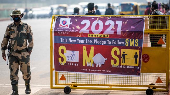 A security personnel walks past a sign on a police barricade near India Gate on New Year's Eve in New Delhi. Picture: AFP