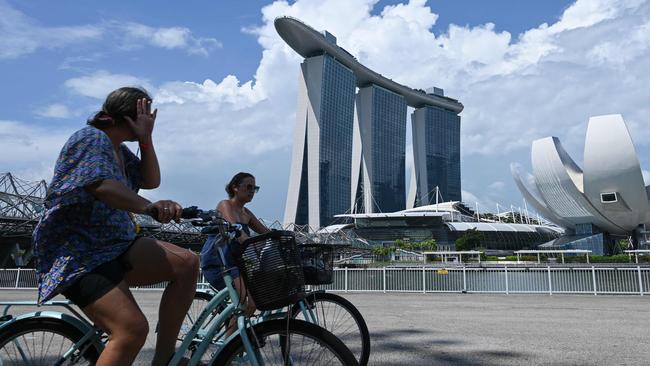 Cyclists pass the Marina Bay Sands hotel and resort in Singapore. Picture: AFP