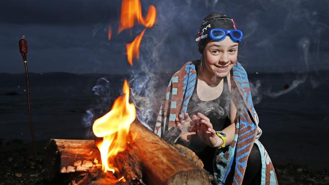 Lucy Clougher, 11 of New Town keeps warm before the solstice swim at Taroona Beach. Picture: ZAK SIMMONDS