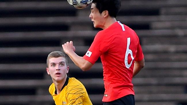 South Korea's Kim Dong-hyun (R) heads the ball as Australia's Riley McGree looks on during the Tokyo 2020 Olympic Games Asian qualifier at the National Olympic Stadium in Phnom Penh on March 26. Picture: TANG CHHIN Sothy / AFP