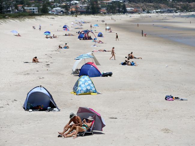 Beachgoers keep cool at Brighton on Monday. Picture: AAP / Kelly Barnes