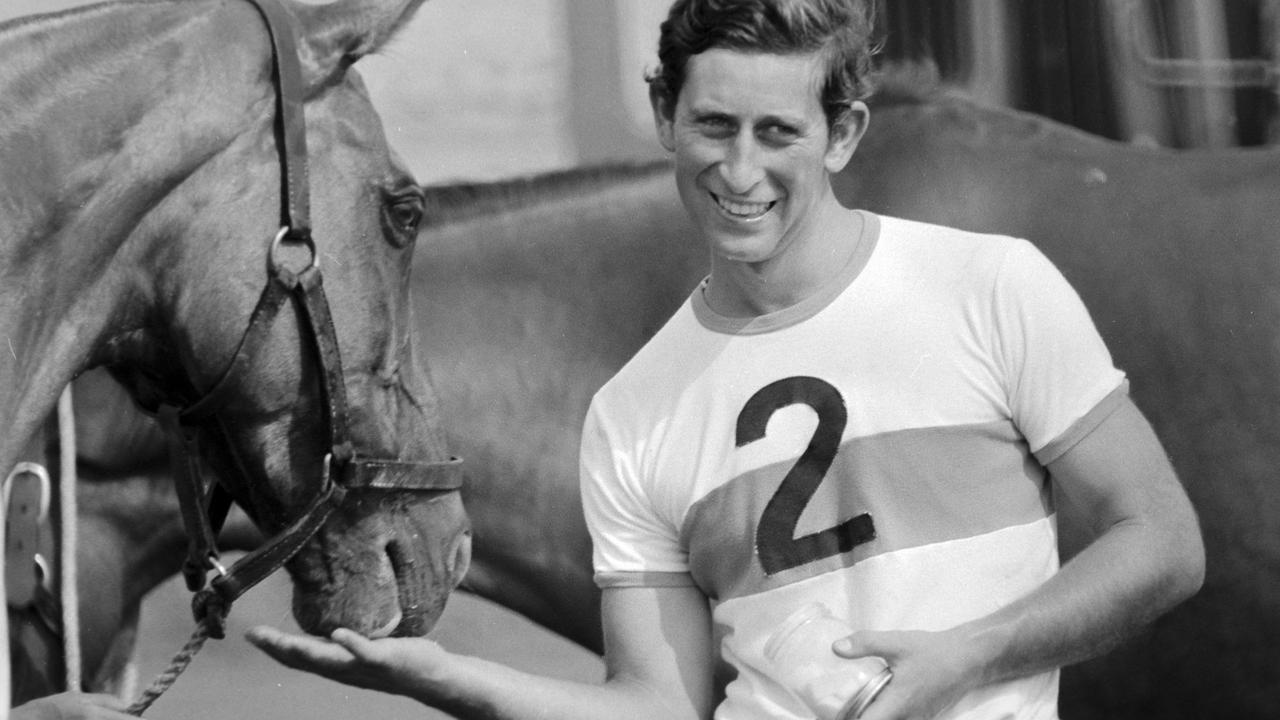 The Prince of Wales feeds his polo ponies sugar cubes on a Sunday morning in 1975. He was 28, single, and in the navy. Picture: Arthur Edwards