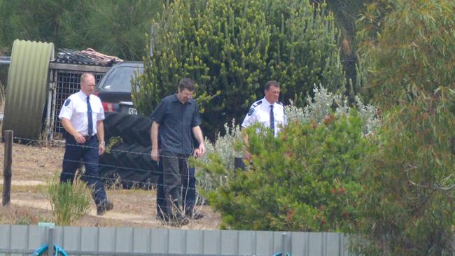 Gene Bristow (middle) with sheriffs’ officers on his property in Meningie. Picture: Brenton Edwards/AAP