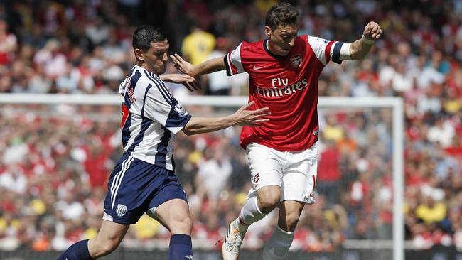 Arsenal’s Mesut Ozil (R) does battle with West Brom’s Graham Dorrans.