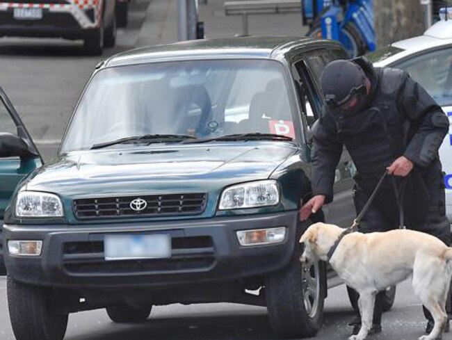 Police and bomb squad with sniffer dogs check over a car on Flinders St and Swanston St. Picture: Jason Edwards