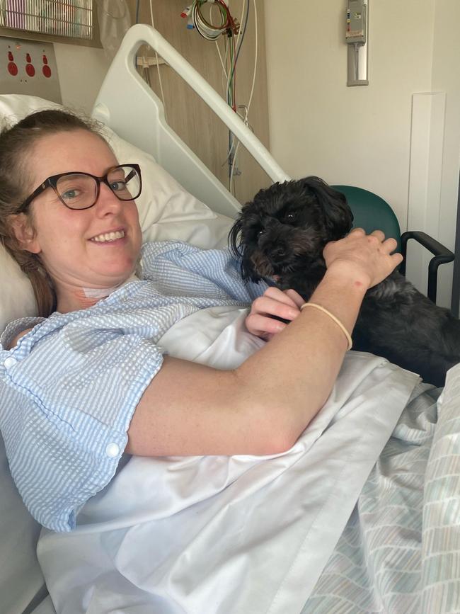 Tasmanian rowing champion and endurance athlete Georgia Nesbitt with her dog Frankie in the Royal Hobart Hospital, as Georgia recovered from injuries she received in a serious bike crash at Tolosa Park in March 2023.