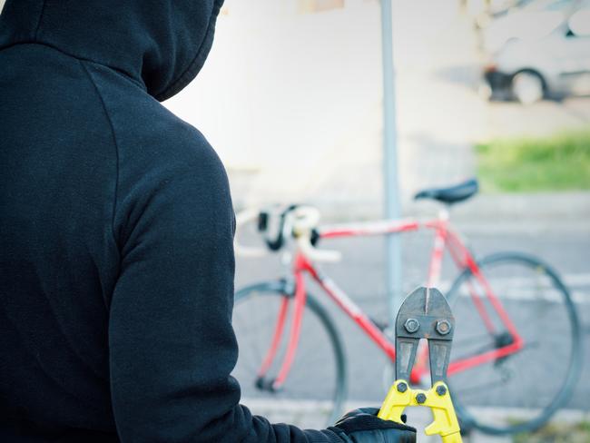 Thief stealing a parked bike in the city street bike theft istock