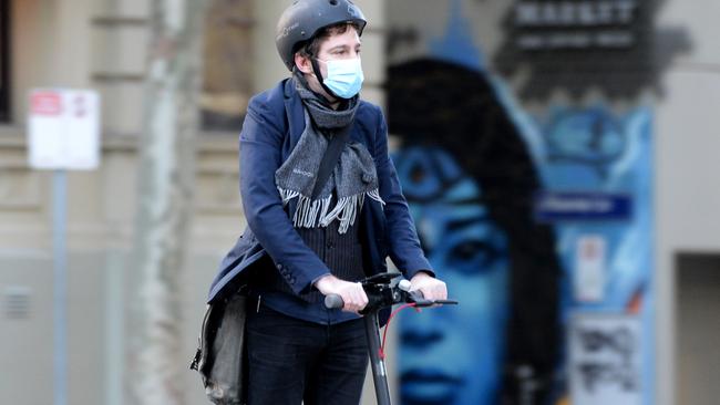 A Melburnian wears a mask while scooting during his daily commute. Picture: NCA NewsWire / Andrew Henshaw