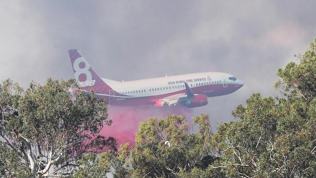 A 737 water bomber in action. Firefighters and water bombing helicopters fight fires on the Sunshine Coast. Pic Peter Wallis