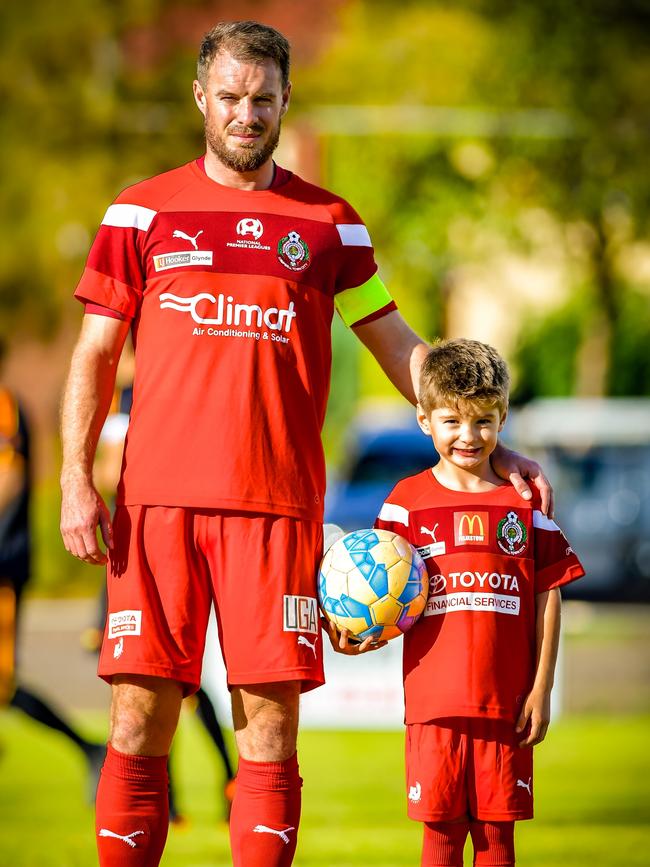 Campbelltown City captain Iain Fyfe with son Lennon, 6, before an NPL match. Picture: Ken Carter