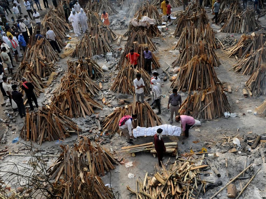 People prepare funeral pyres of those who died from coronavirus during a mass cremation at a crematorium in New Delhi. Picture: Imtiyaz Khan