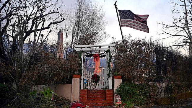 A US flag and Christmas decorations are seen on the remains of a home after the passage of the Palisades Fire in Pacific Palisades. Picture: AFP