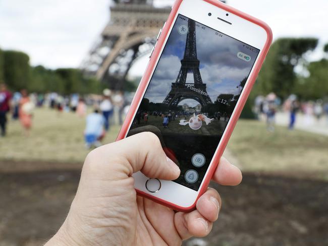 A gamer catches a Pokemon infront of the Eiffiel Tower in Paris, France. Picture: AFP