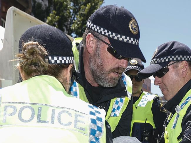 Extinction Rebellion Tasmania blocked off Liverpool Street to cars with a street party and glued themselves to the street and each other before being arrested.  A  member of   Extinction Rebellion Tasmania is arrested by Tasmanian Police. Picture: Zak Simmonds