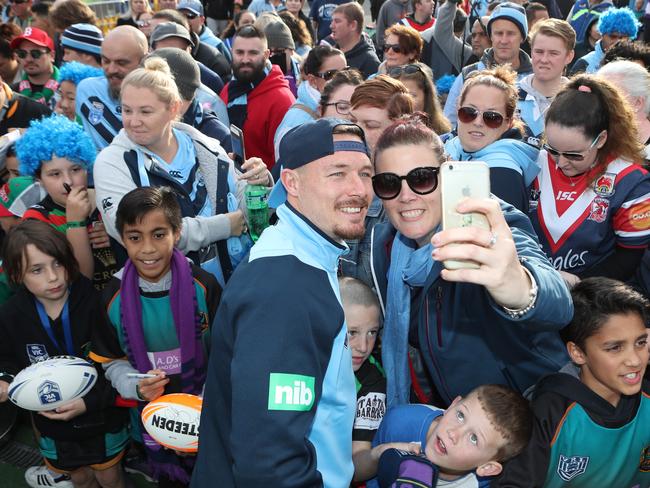 The Blues embraced the fan support: Damien Cook (C) signs autographs as NSW arrive in Melbourne. Pic: AAP