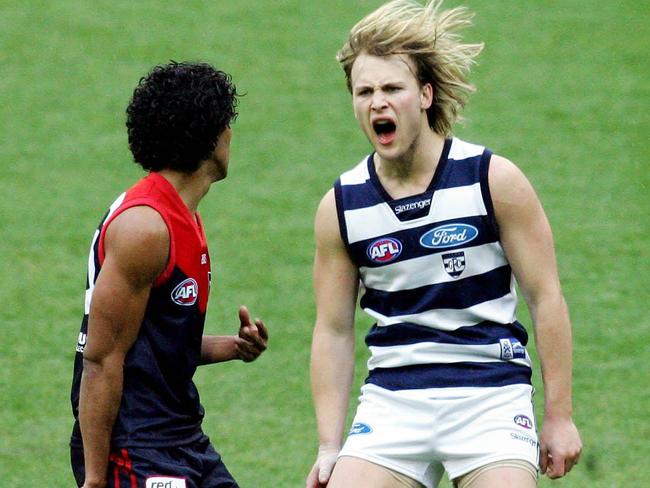 Gary Ablett, sporting slightly longer hair, lets Aaron Davey know about one of his goals.