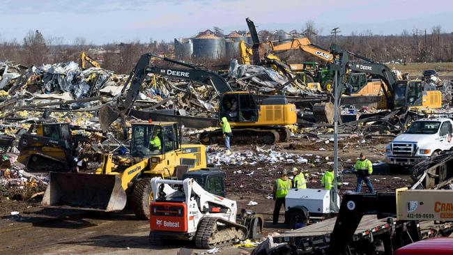 Workers toil through the destruction at Mayfield Consumer Products Candle Factory after it was destroyed by a tornado with workers inside, in Mayfield, Kentucky.