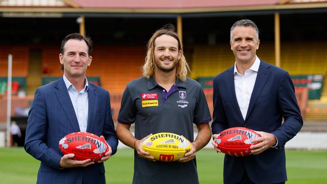 Andrew Dillon, on the left, alongside James Aish of the Dockers and South Australian Premier Peter Malinauskas. Photo by Dylan Burns/AFL Photos via Getty Images.