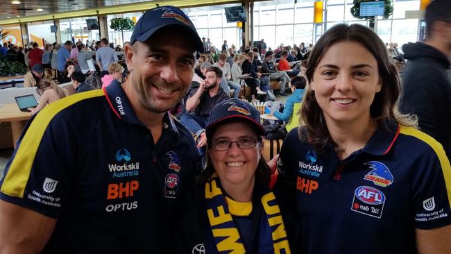 Adelaide Crows fan Jay Gardiner, centre, with Andrew McLeod and Ebony Marinoff at Hobart International Airport on Sunday. Picture: Supplied