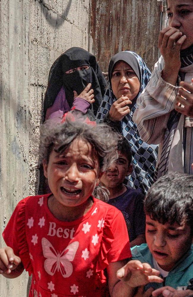 Children flee following Israeli bombardment in Nuseirat in the central Gaza Strip. Garbage, dirty water and insect bites along with bombings make it a “living hell.” Picture: AFP