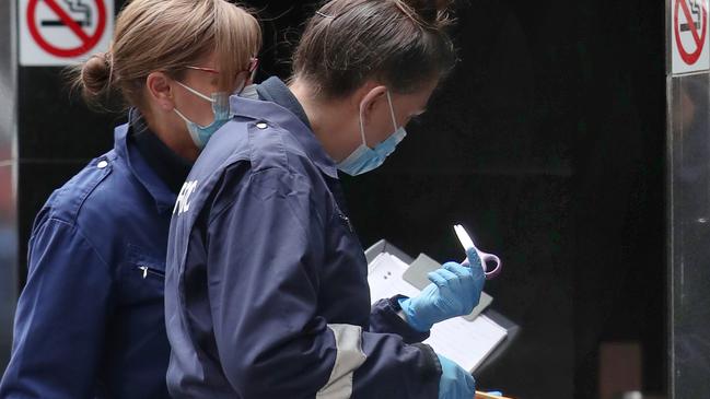 Forensic police examine a pair of scissors found at the scene. Picture: David Crosling