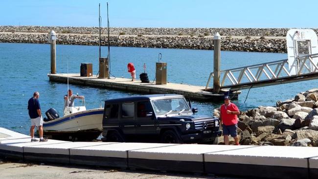 Stephen Marks (red top) and associates removing a boat from the Marina St Vincent on Monday, March 30 after the State Government terminated their lease.