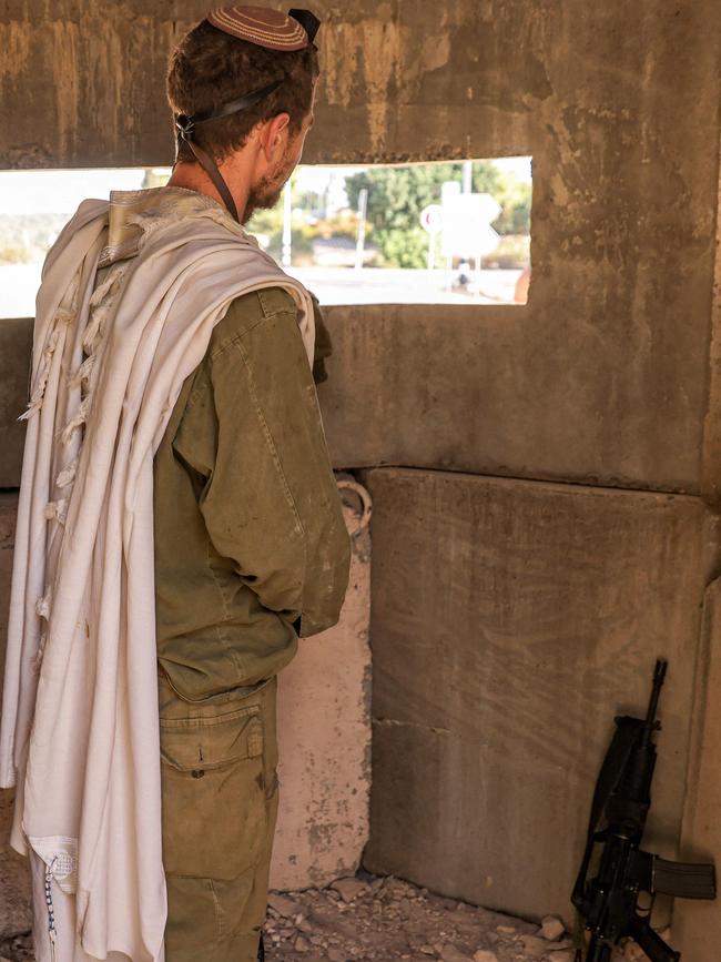 An Israeli army soldier wearing a prayer shawl prays inside a fortified bunker at a position in the upper Galilee.