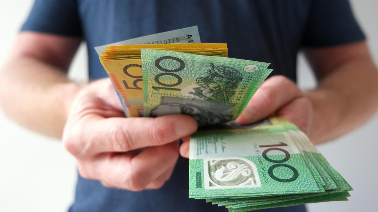 A man counting Australian dollar bills. A picture that describes buying, paying, handing out money, or showing money.