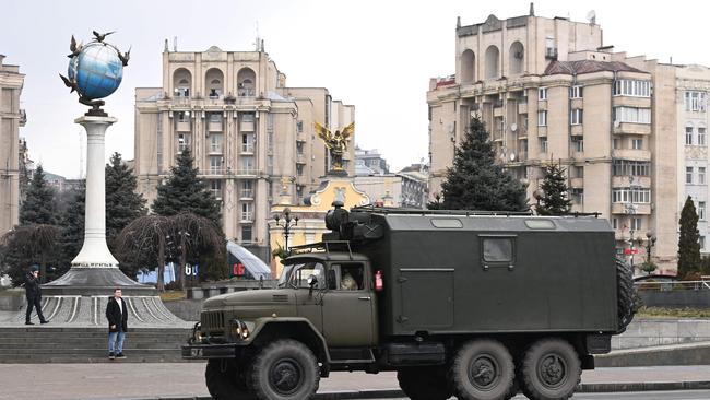 A military cargo truck rolls through central Kyiv as air raid sirens rang out and cities across Ukraine were hit with what Ukrainian officials said were Russian missile strikes and artillery.