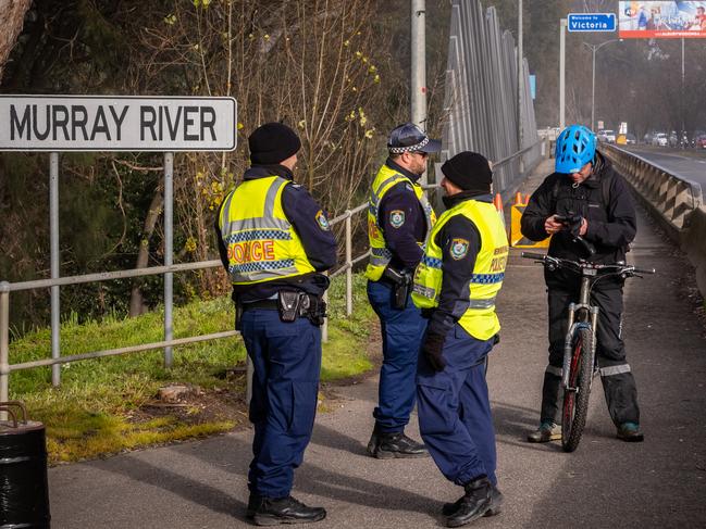 ALBURY, AUSTRALIA - NewsWire Photos JULY 22, 2020:    A man riding his bike across the Murray River border in Albury is checked by police. Restrictions get tightened from today at border crossings.Picture: NCA NewsWire / Simon Dallinger